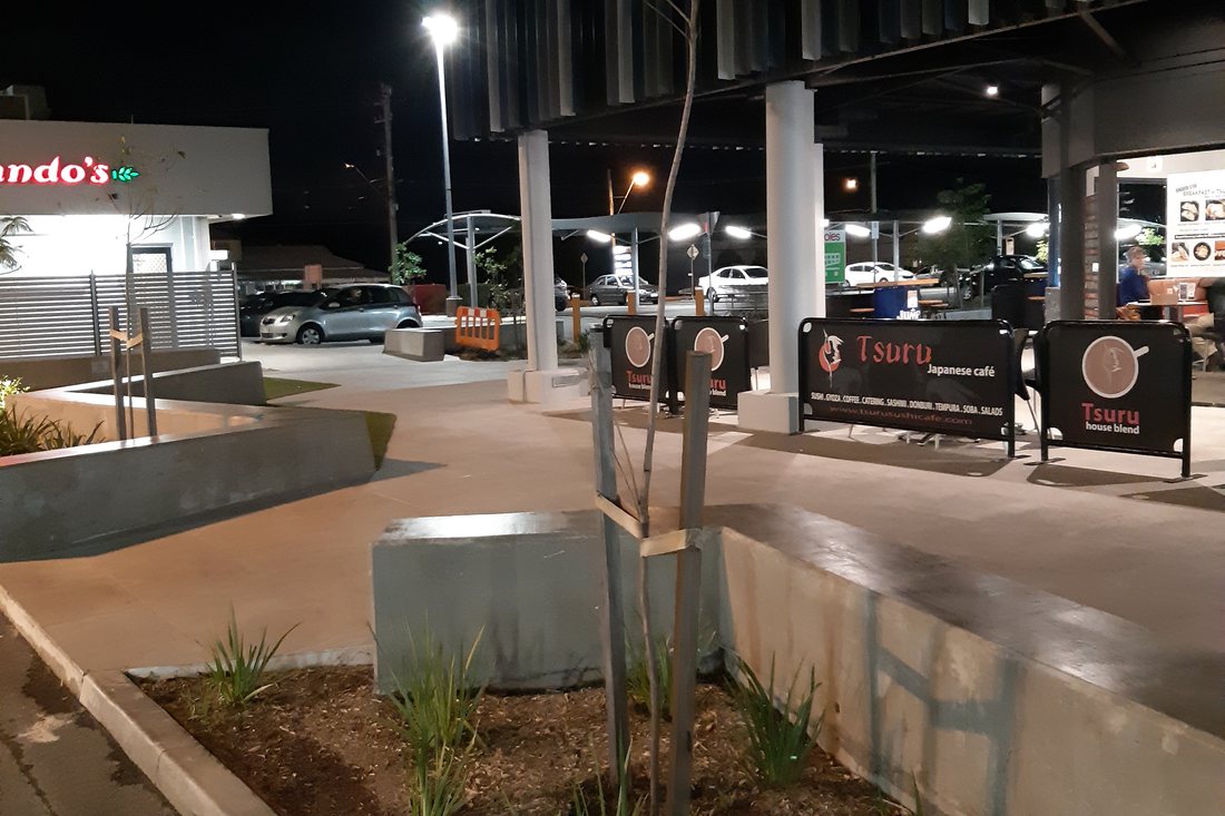 Albany Creek Village — night view of the centre with feature lighting and palms